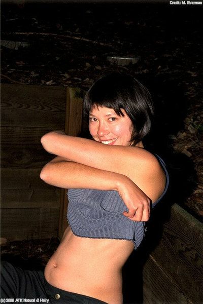 Smiling Asian babe Amanda gets outdoors and reveals hairy parts of body