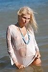 Slim blonde babe Wiska poses nude and in wet white blouse at the seaside