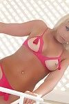 Blonde Ann Angel in barely there pink bikini shows her tits and buttocks